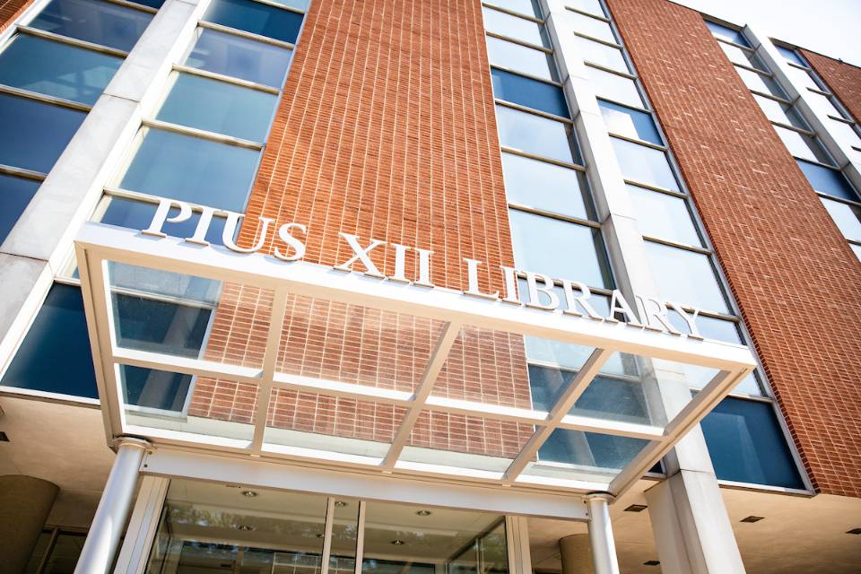 A closeup of the Pius Library sign above the library's south door.