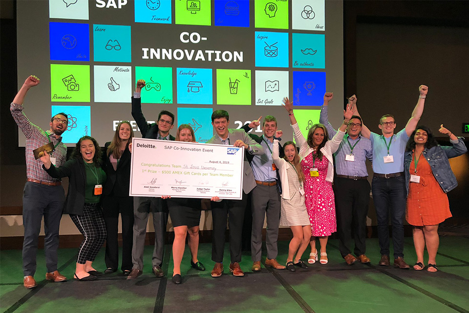 Chaifetz Students celebrate on stage with giant check after winning the 2019 Deloitte-SAP Co-Innovation Event