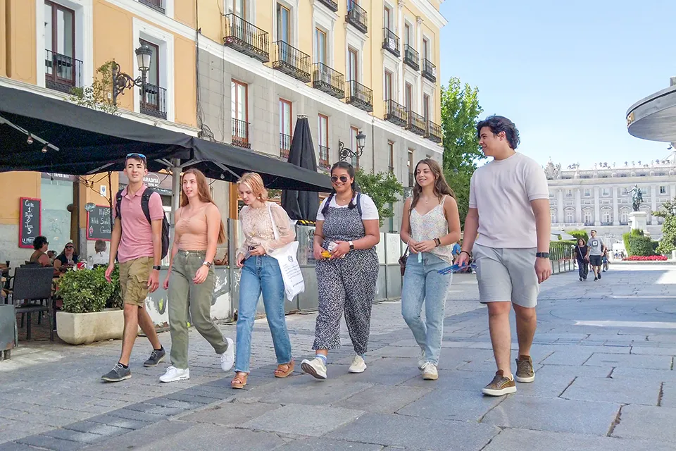 Students walking the streets of madrid close to the Royal Palace.