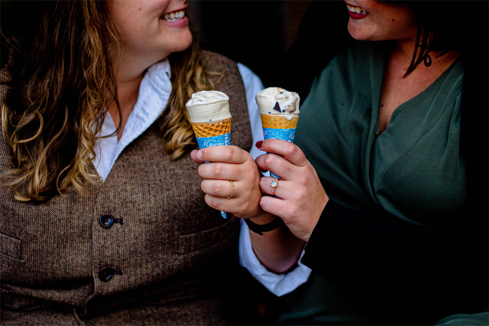 Two women sharing ice cream cones