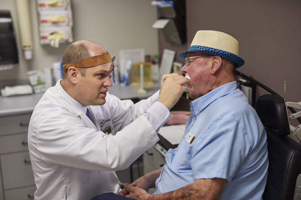 A member of the department examines a patient's mouth.