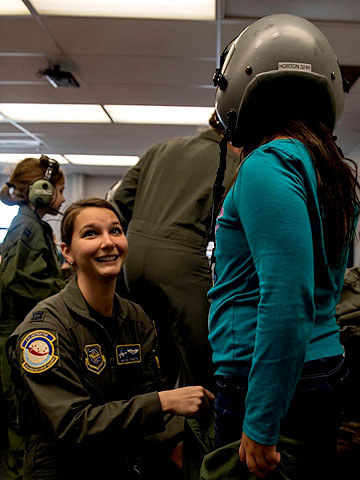 Alicia Canetta helps a student try on a flight helmet