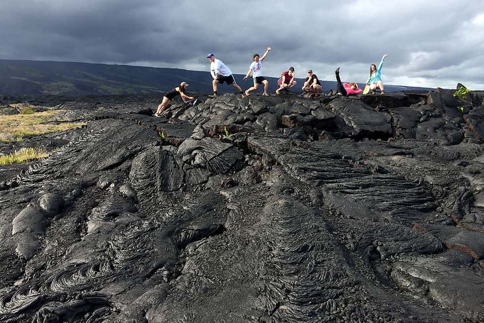 SLU students pose on a lava field in Hawaii on a past geosciences trip led by John Encarnacion, Ph.D.