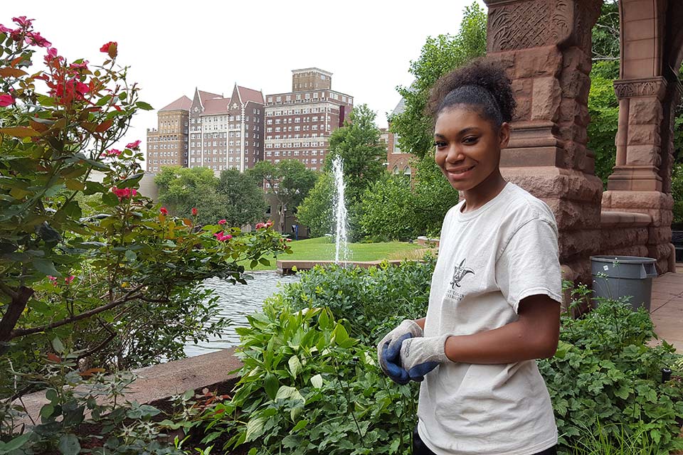 Heaven Persaud, a student worker in the grounds department, maintains the butterfly garden this past summer outside of Cupples House.  