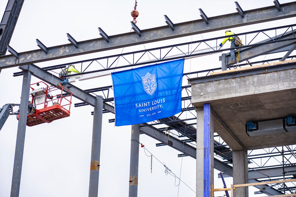 SLU tops off the ISE Building as the last external frame beam is hoisted into place.