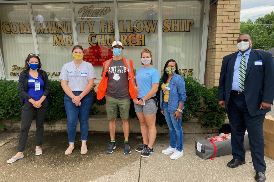 SLU volunteers Rebecca Cunningham, Hannah Gaynier, Justin Vilbig, and Laura Brugger gather with a Metropolitan Congregations United (MCU) representative and Rev. Rodrick K. Burton at the Aug. 1 PPE drive. Submitted photo