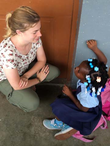 A volunteer talks with a young student.