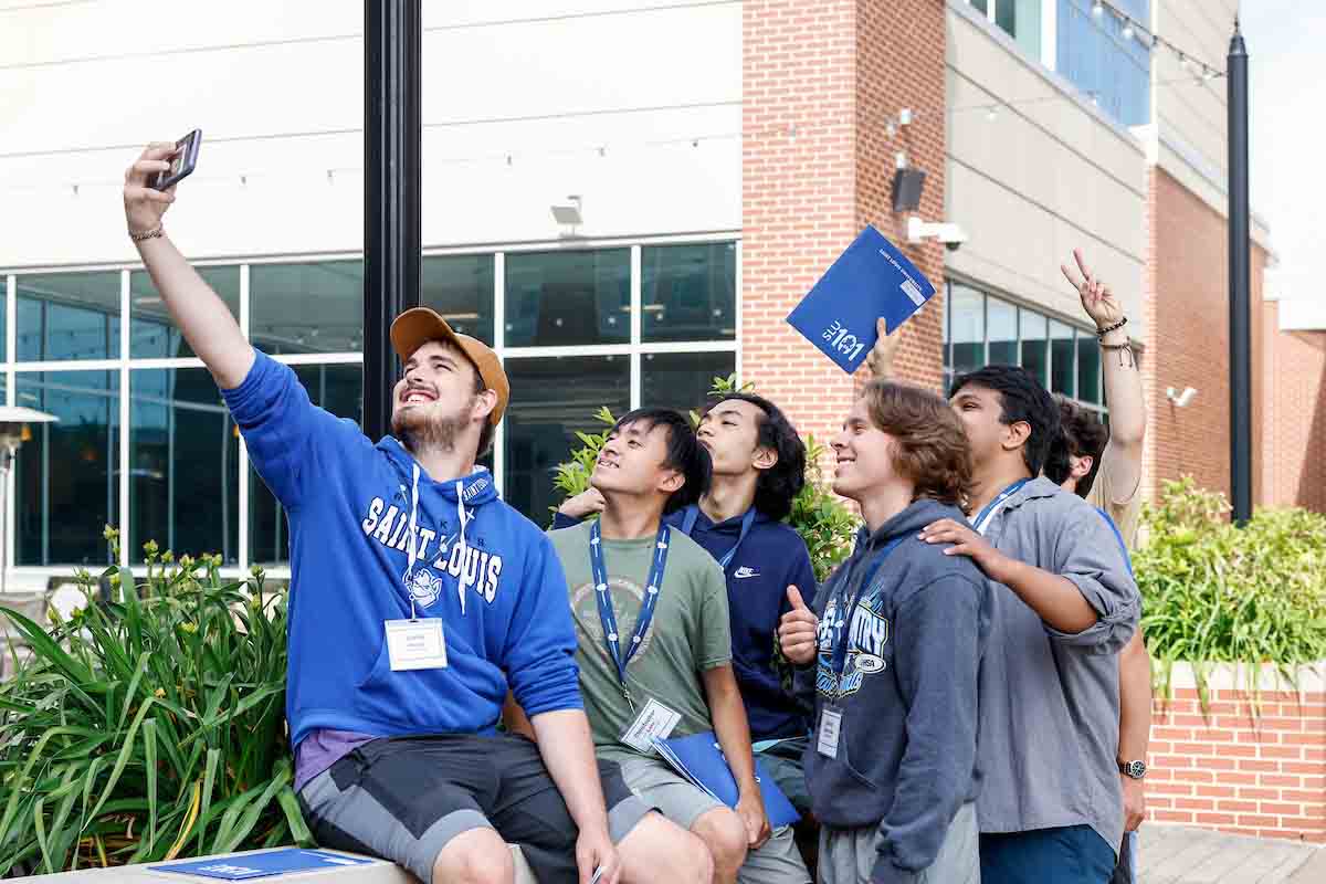 Students take a selfie in Bicentennial Plaza as part of a SLU 101 scavenger hunt. 

