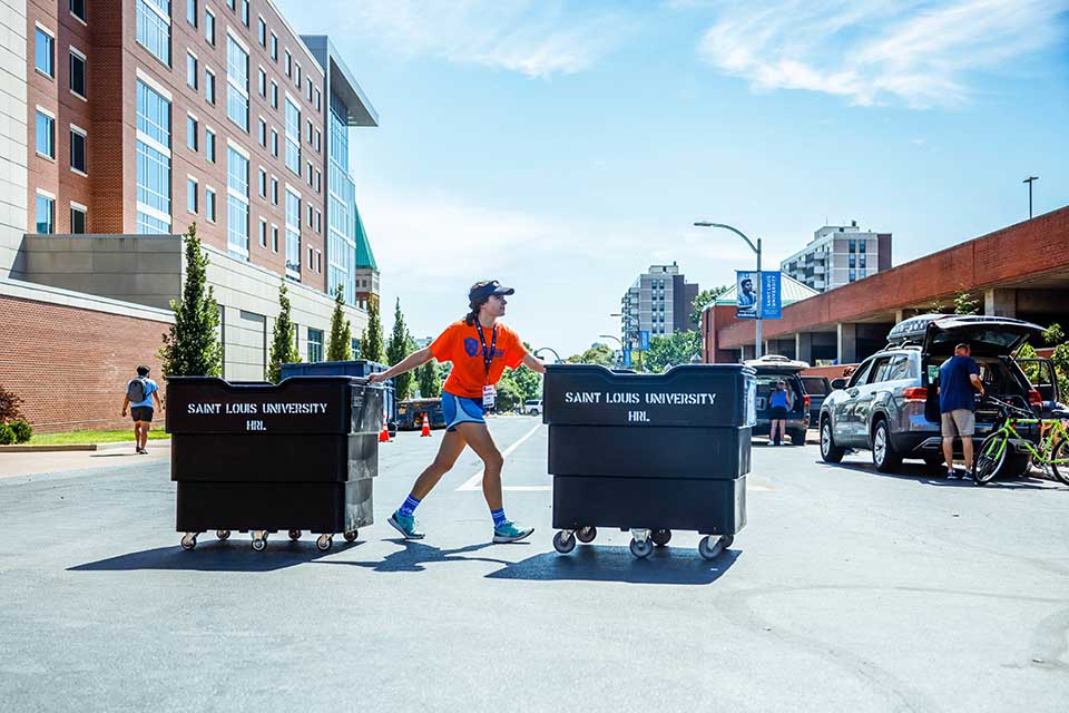 An Oriflamme leader prepares to fill up bins to help another new student move into their residence hall during the second day of move-in on Aug. 19, 2022. Photo by Sarah Conroy. 