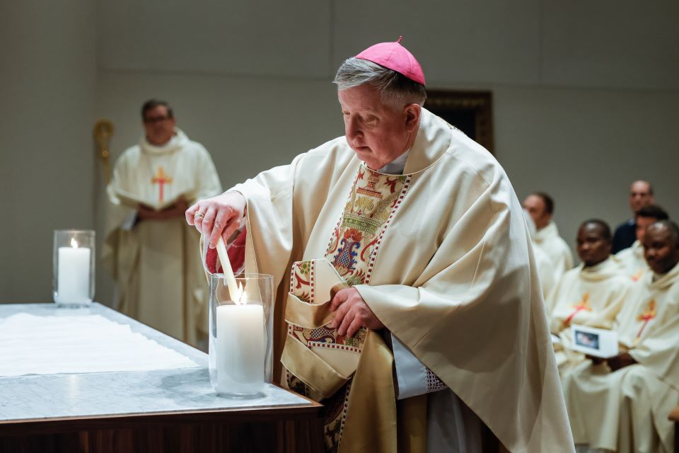 Archbishop Mitchell T. Rozanski lights a candle to consecrate the altar of the Jesuit Center Chapel on October 25, 2022. Photo by Sarah Conroy. 