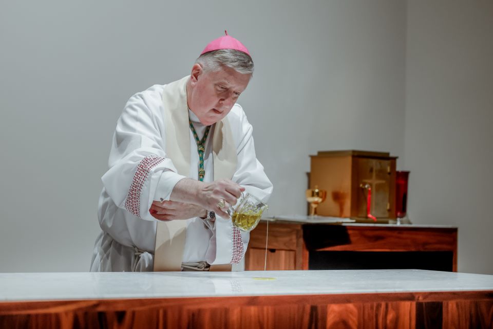 Archbishop Mitchell T. Rozanski pours chrism to consecrate the altar of the Jesuit Center Chapel on October 25, 2022. Photo by Sarah Conroy. 