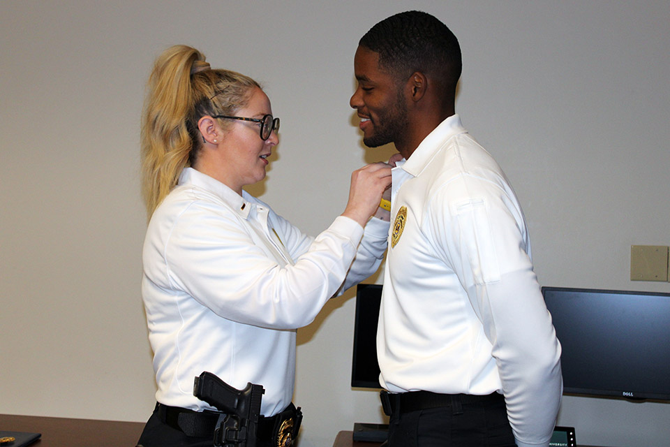 Johsiey Litherland, Lieutenant/Training and Accreditation Manager, pins Joshua Johnson, Lieutenant/Community Engagement Manager, during the SLU DPS pinning ceremony on Wednesday, Nov. 16. Photo by Joe Barker. 