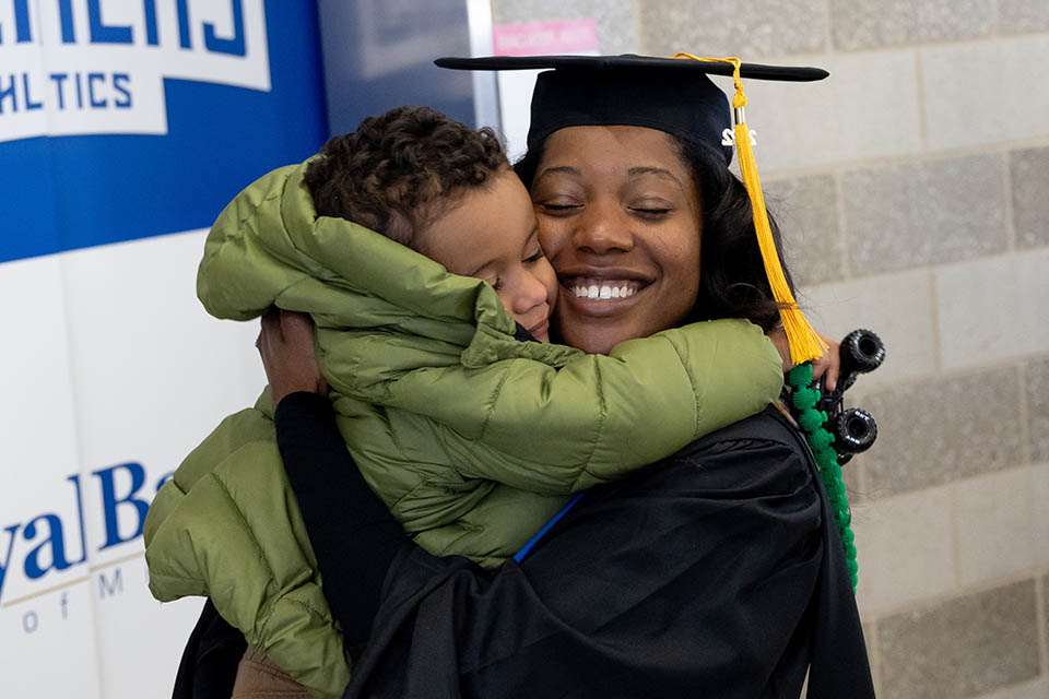 A graduate celebrates with her loved one after the 2022 Midyear Commencement ceremony at Chaifetz Arena on Saturday, Dec. 17, 2022. 
Photo by Sarah Conroy.