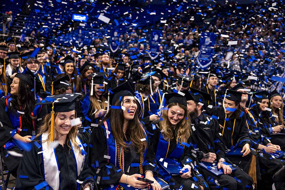 Graduates watch the confetti fall at the conclusion of the 2022 Midyear Commencement ceremony at Chaifetz Arena on Saturday, Dec. 17, 2022. Photo by Sarah Conroy. 
