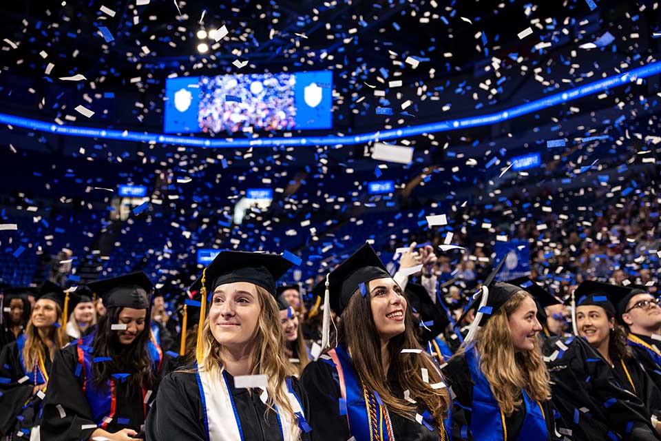 Graduates watch the confetti fall at the conclusion of the 2022 Midyear Commencement ceremony at Chaifetz Arena on Saturday, Dec. 17, 2022. Photo by Sarah Conroy.