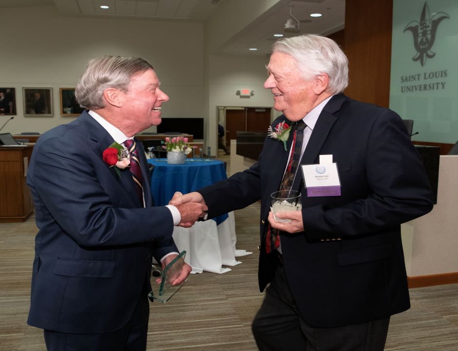 Jerry Carmody greets Rudy Hasl at the Order of the Fleur de Lis Hall of Fame