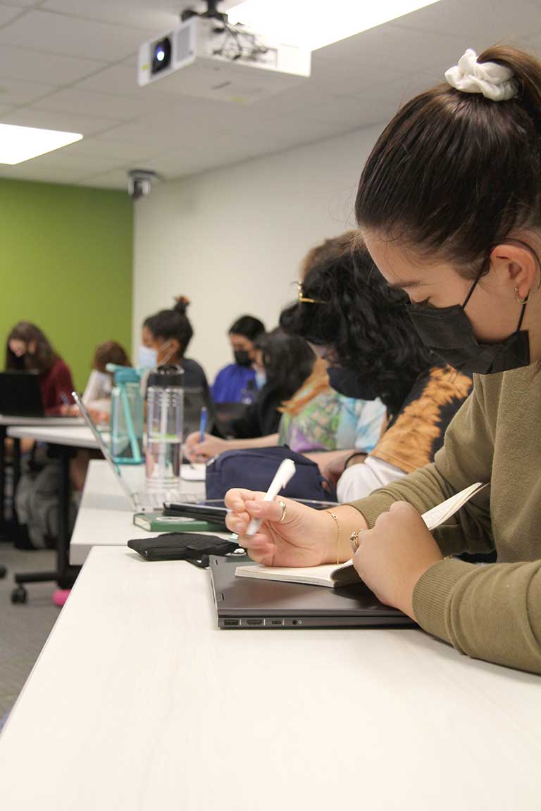 Srudents writing down their thoughts as they participate in class