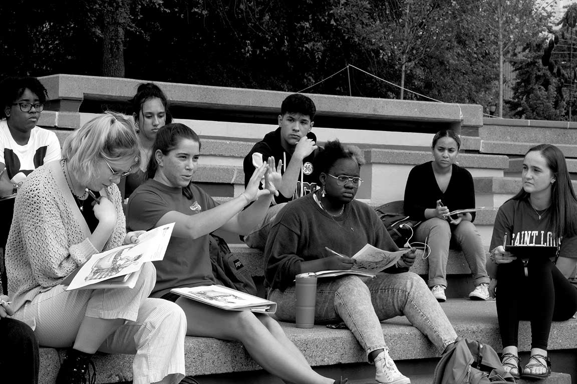 Slide 1: A group of students listening on the clockt ower stairs