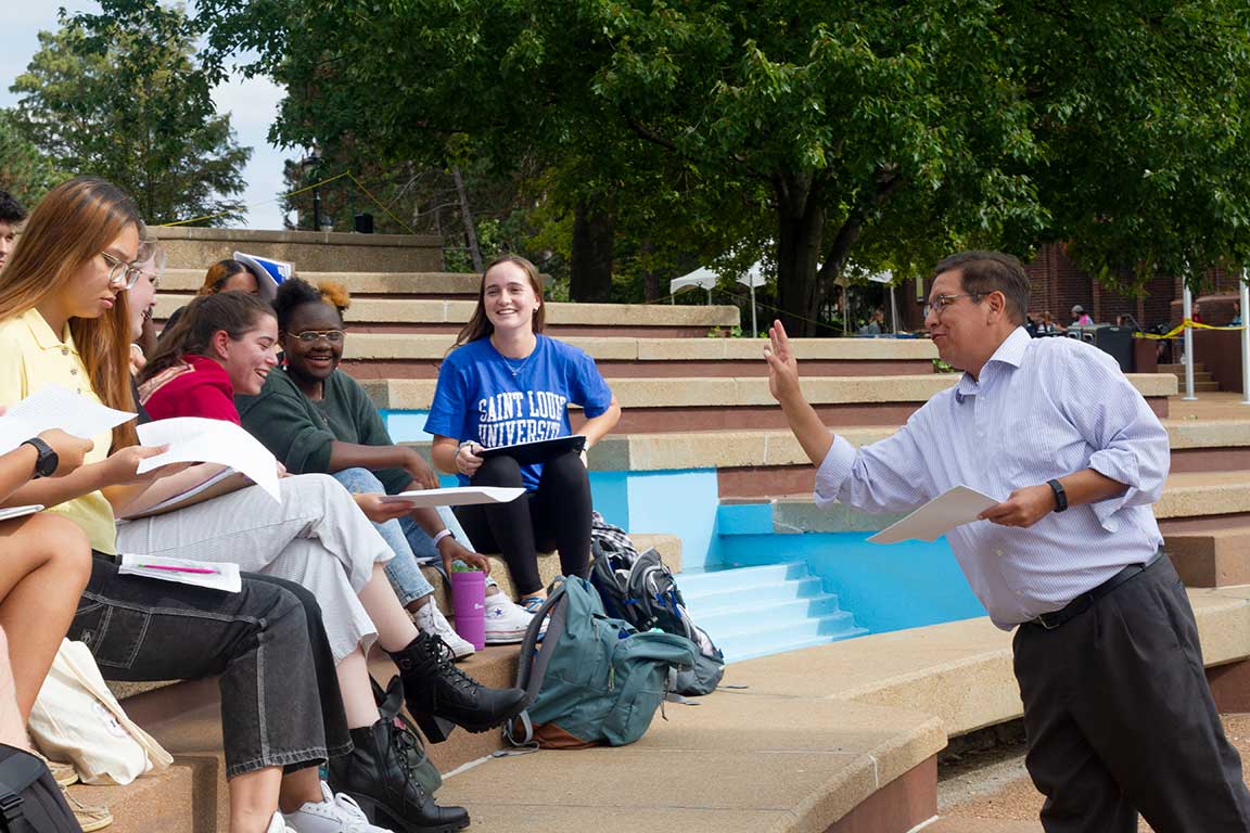 Slide 5 : A group of students listening on the clockt ower stairs