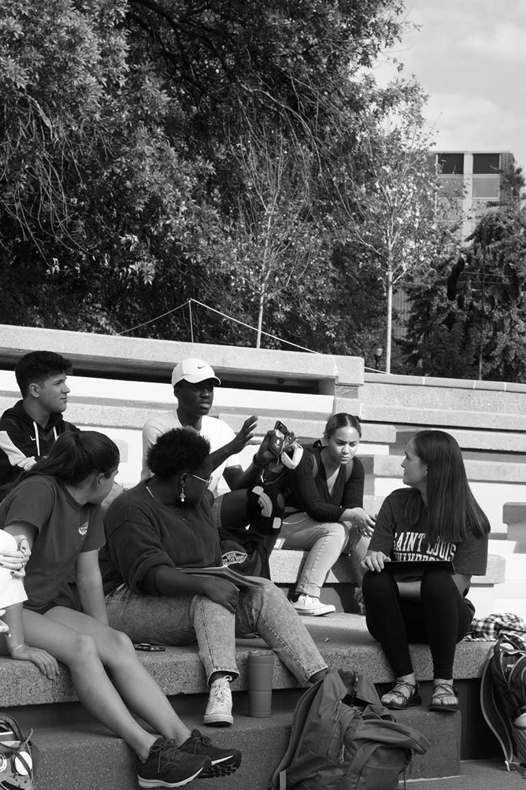 Slide 3: A group of students listening on the clockt ower stairs