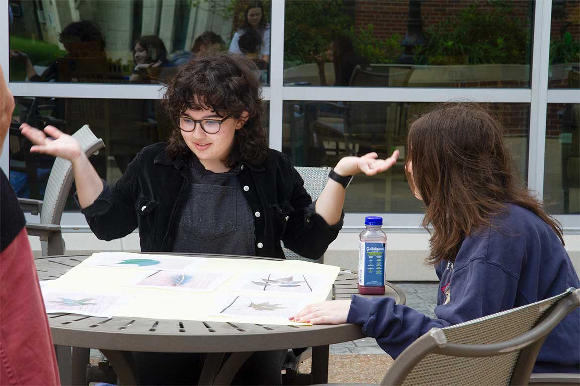 Slide 2: Animated student at table  of Ignite Communication Seminar