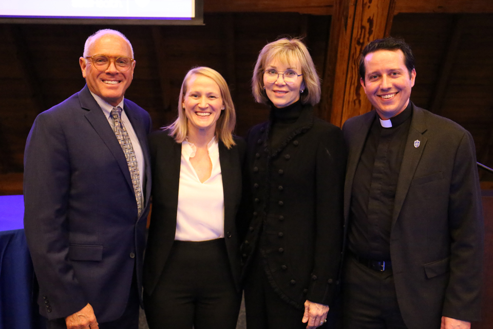Four participants stand and smile at the camera.