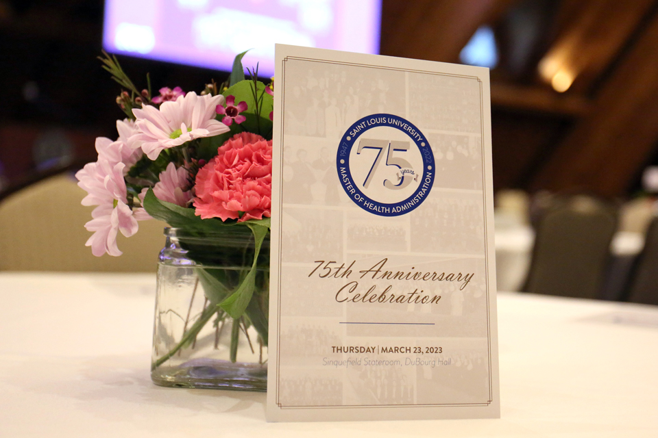 The event program sits on a centerpiece of flowers on a table.