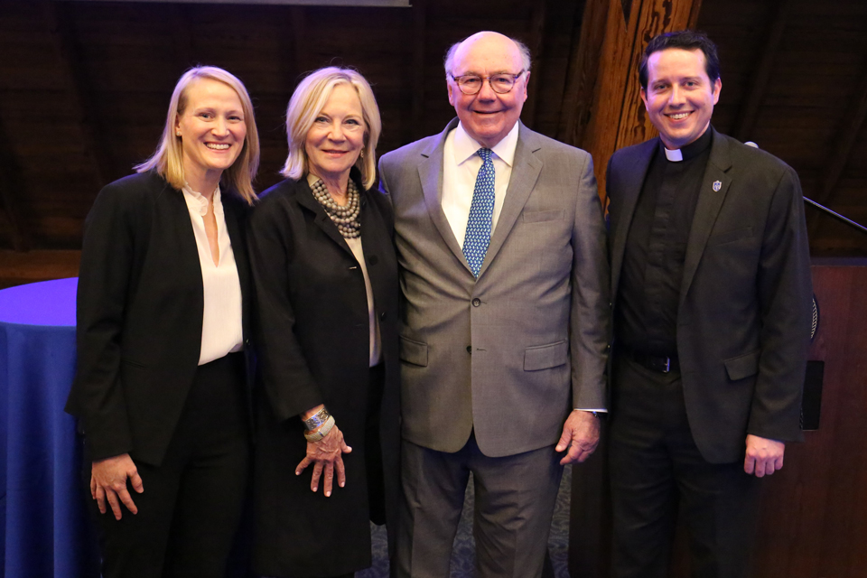 Four participants stand and smile at the camera.