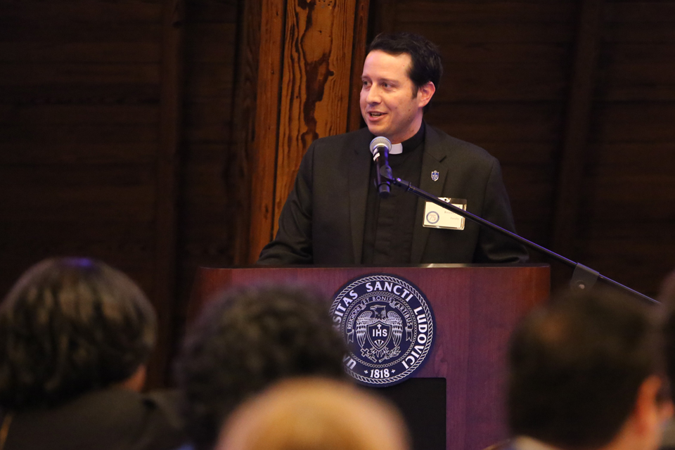 A speaker speaks to the event participants at the lectern.
