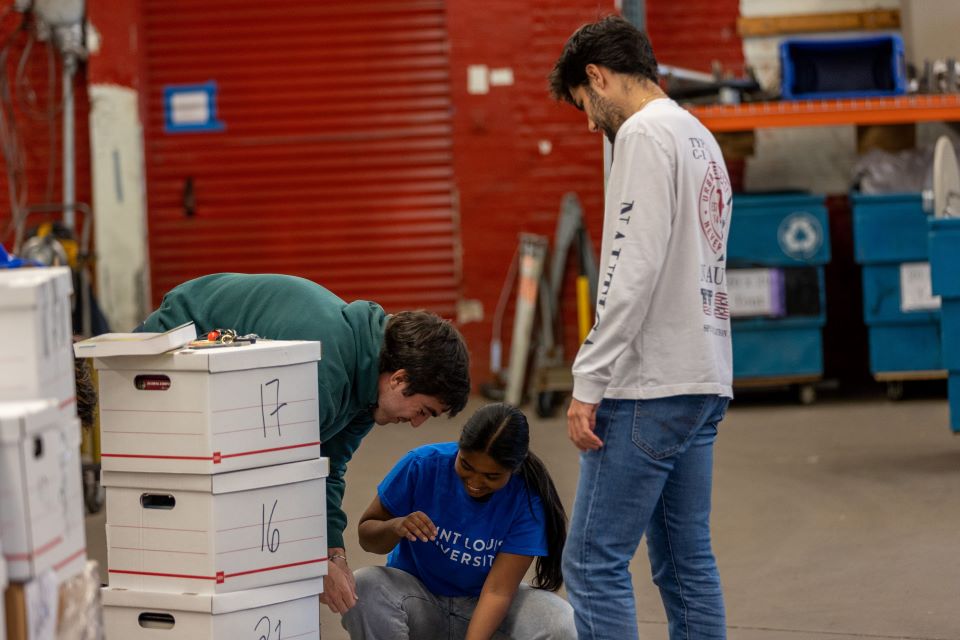 Vice President of the International Business Club Subah Shovik, pictured center, starts a new pallet.Photo by David Malone. 