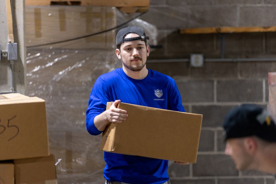 Caleb Coyne, president of the International Business Club, carries a box. Photo by David Malone. 