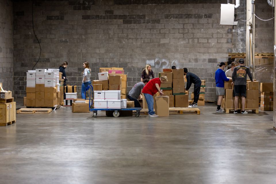 Volunteers and members of the International Business Club stack pallets of books. Photo by David Malone. 