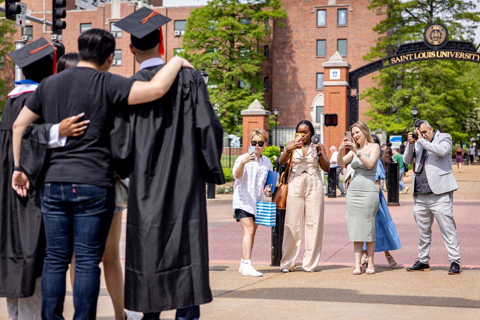 Graduates pose for photos under the gateway on May 19, 2023. Photo by Sarah Conroy.