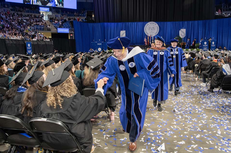 Commencement speaker John O'Leary greets graduates following the ceremony on Saturday, May 20. Photo by Steve Dolan.