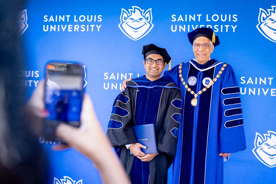 SLU President Fred P. Pestello, Ph.D., poses for a picture with a graduate at the Spring 2023 Commencement Ceremony. Photo by Sarah Conroy.