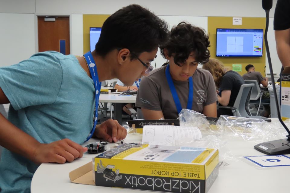 STEM Camp students Aadit Mehta and Isaac Gutierrez begin to build a robotic device during a CHROME Lab activity. Photo by Maggie Rotermund.