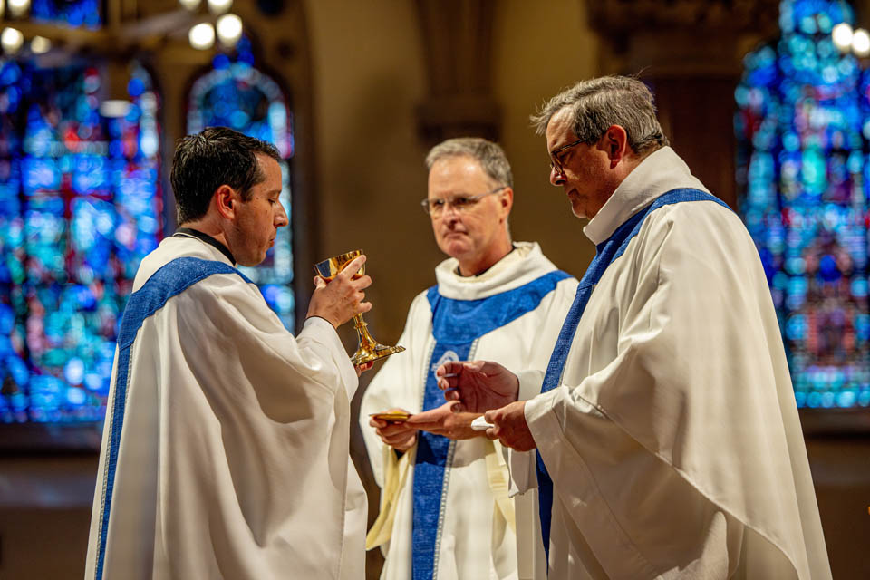 Michael Rozier, S.J., Ph.D., takes communion after his final vows during the Mass of the Holy Spirit in St. Francis Xavier College Church on Thursday, Aug. 24. Photo by Sarah Conroy. 