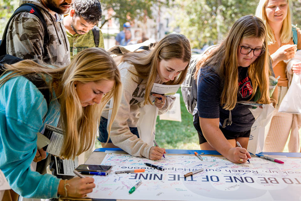 Students sign a banner committing to help prevent suicide during Fresh Check Day on Wednesday, Sept. 6. Photo Sarah Conroy.