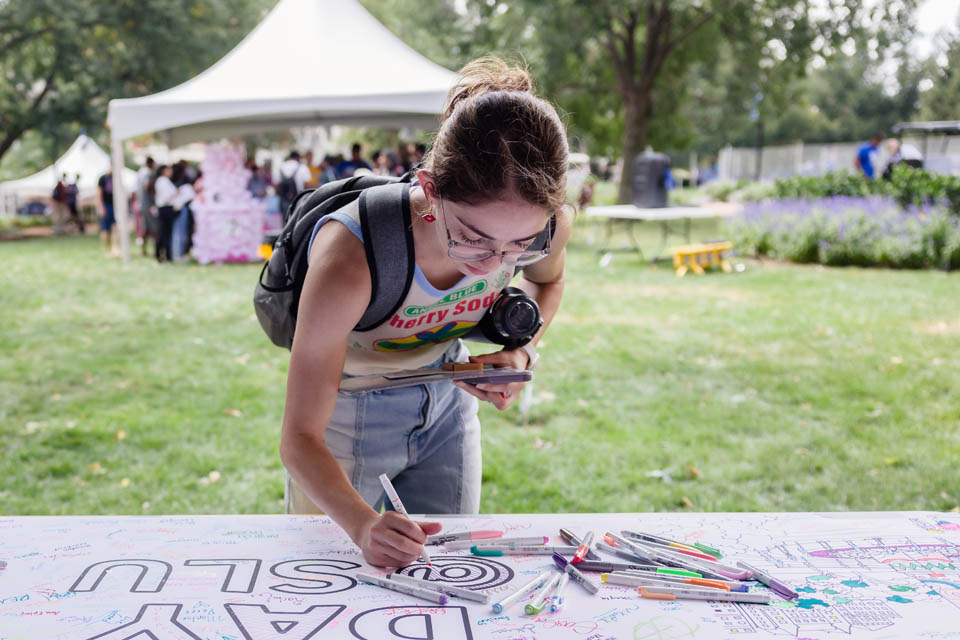 A student signs the banner during Fresh Check Day on Wednesday, Sept. 6. Photo Sarah Conroy.