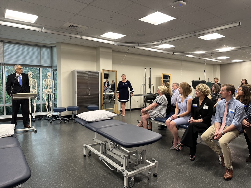 Dr. Pestello stands at a podium in the Gioia Learning Lab speaking to a group of faculty and Gioia family members. 
