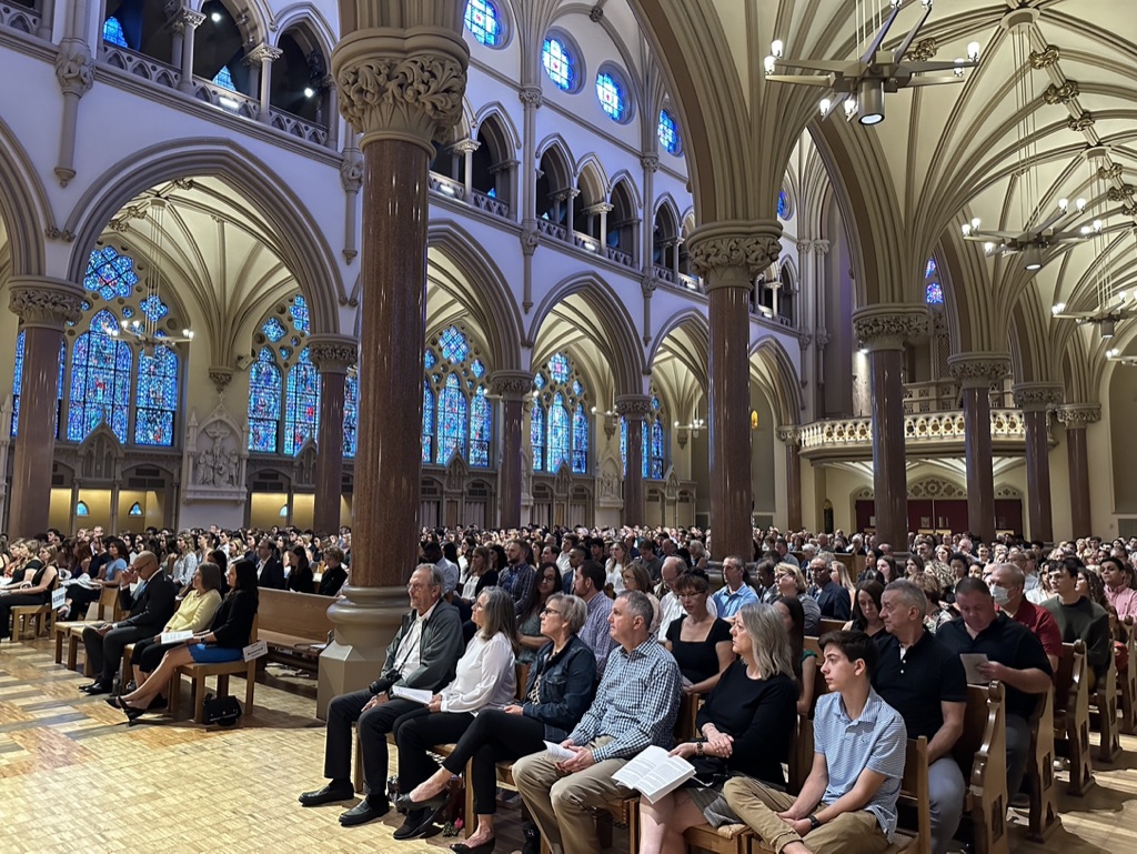 Rows of people fill college church for the white coat ceremony. 