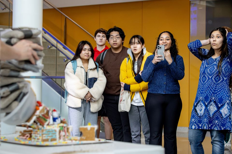 Teams watch as a gingerbread house crumbles during the SSE Holiday Innovation Challenge Testing on December 8, 2023. Teams were challenged to create gingerbread houses that could withstand weight from sandbags. Photo by Sarah Conroy. 