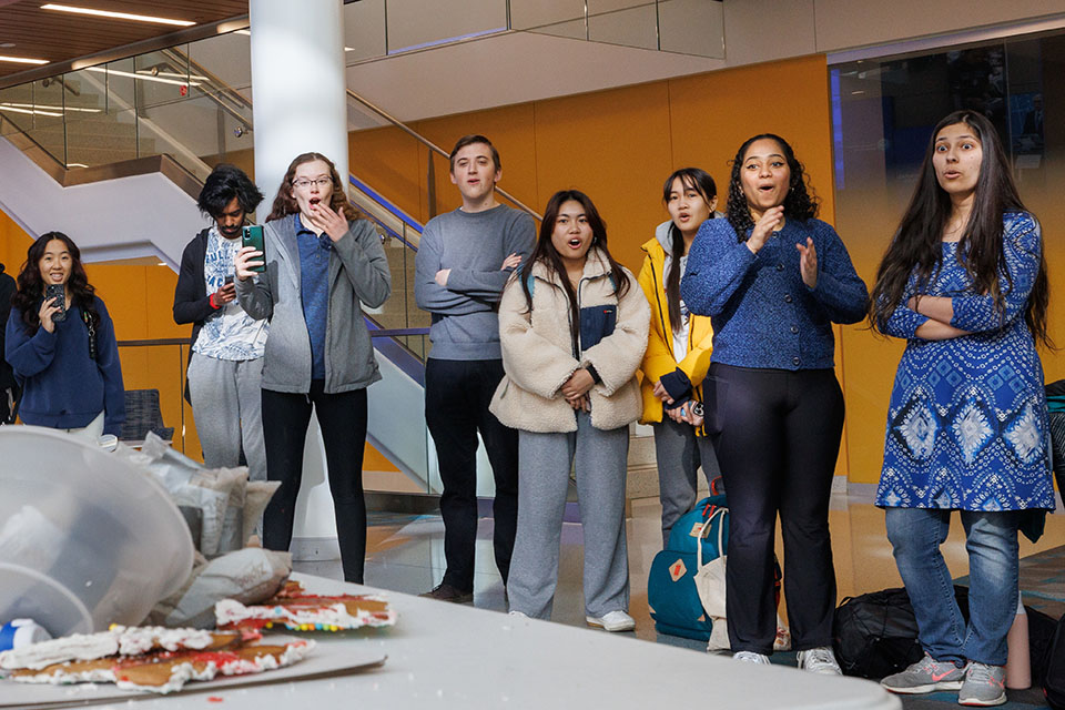 Teams react to a gingerbread house collapse during the SSE Holiday Innovation Challenge Testing on December 8, 2023. Teams were challenged to create gingerbread houses that could withstand weight from sandbags. Photo by Sarah Conroy. 