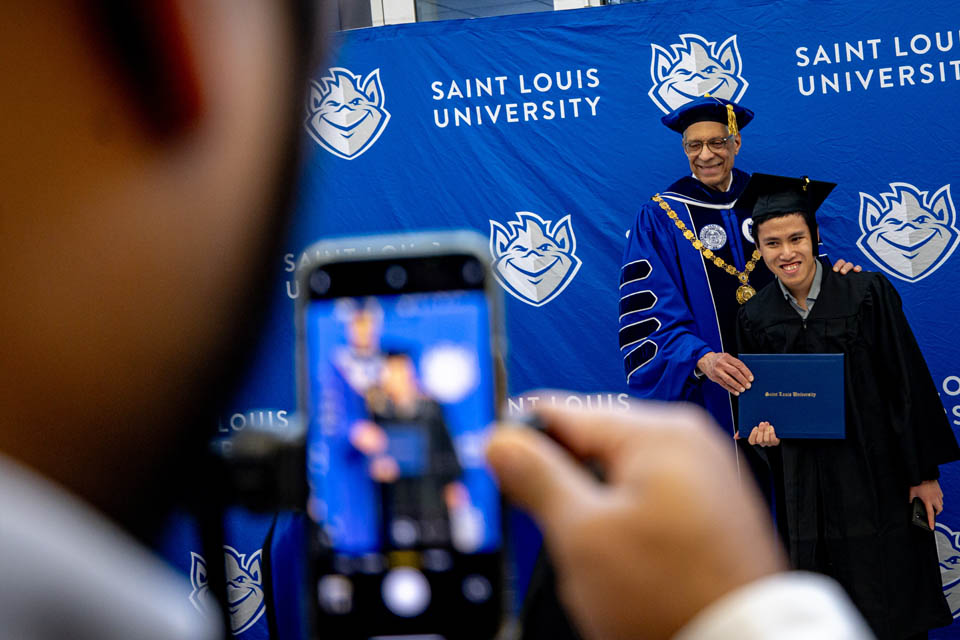 President Fred P. Pestello, Ph.D., takes a selfie with graduates after the Midyear Commencement on Dec. 16, 2023. Photo by Sarah Conroy.