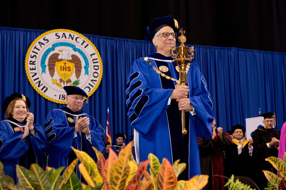 Saint Louis University President Fred P. Pestello, Ph.D., holds the University mace during his inauguration ceremony on Oct. 3, 2014, at Chaifetz Arena. Photo courtesy of Saint Louis University. 