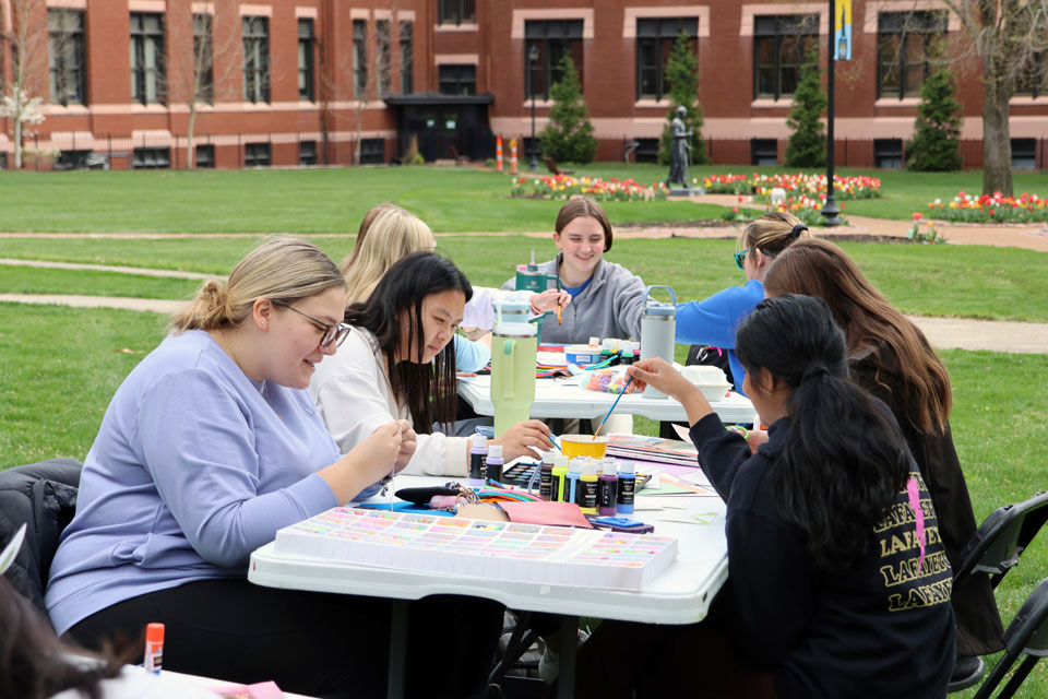Students work on their art outside DuBourg Hall during Art Hives on Friday, April 5. Photo by Joe Barker.