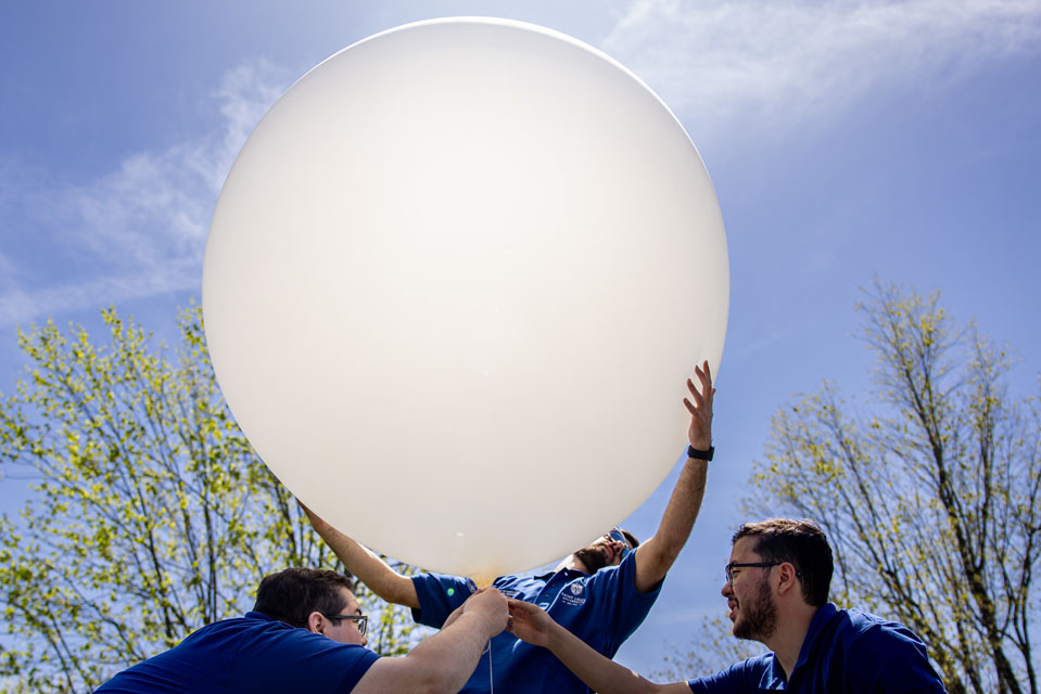 Jack Rotter, Carter Hickel, and Riley Jackson, prepare to launch a weather balloon during the solar eclipse. Photo by Sarah Conroy. 