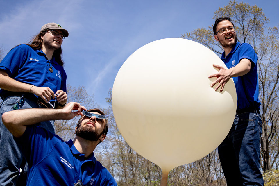 From left, Jimmy Bergmann, Carter Hickel, and Riley Jackson, prepare to launch a weather balloon during the solar eclipse at Trail of Tears State Park on April 8, 2024. Photo by Sarah Conroy. 