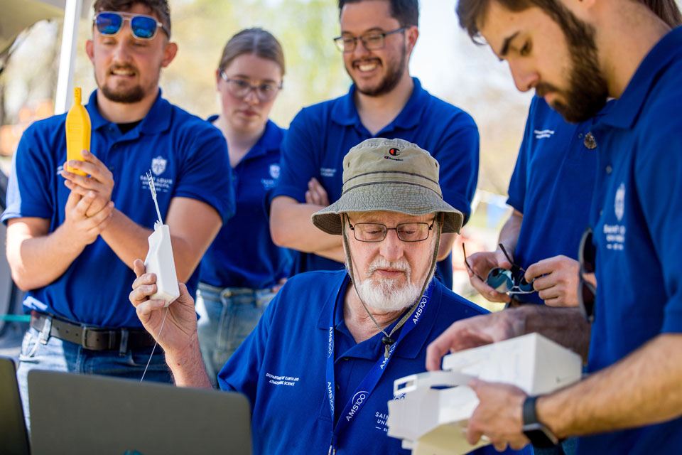Robert Pasken, Ph.D., associate professor of meteorology, center, prepares equipment to launch weather balloons during the solar eclipse at Trail of Tears State Park on April 8, 2024.Photo by Sarah Conroy. 