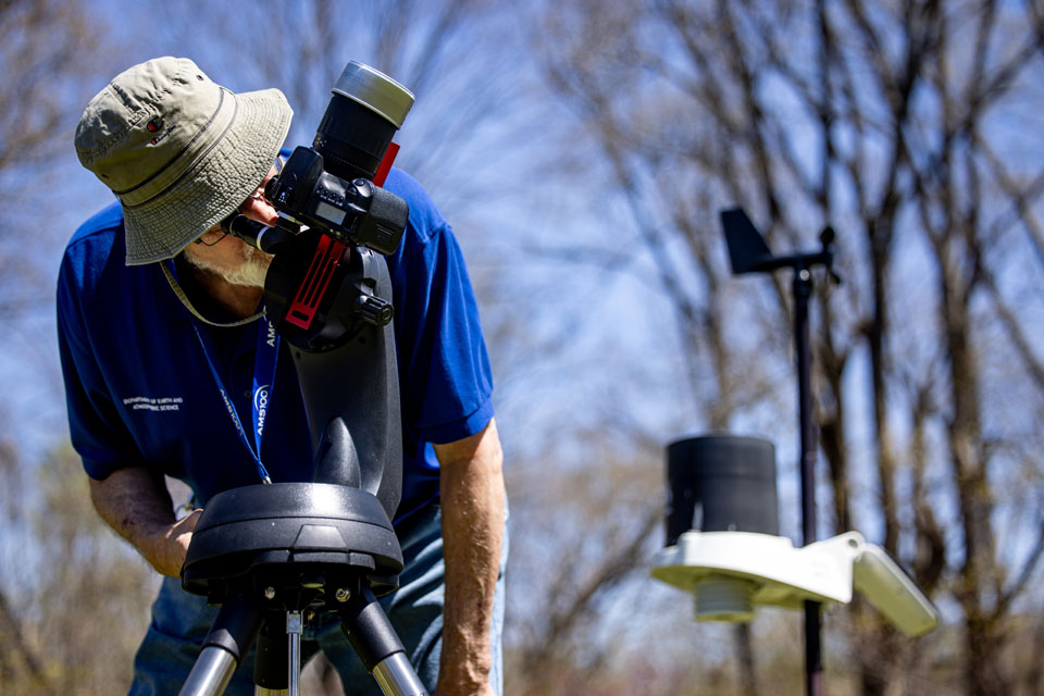 Robert Pasken, Ph.D., associate professor of meteorology at SLU, sets up equipment to photograph the solar eclipse at Trail of Tears State Park on April 8, 2024. Photo by Sarah Conroy. 